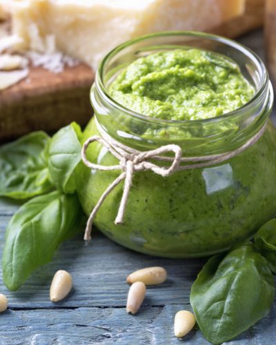 Homemade pesto with pine nuts on a blue wooden background